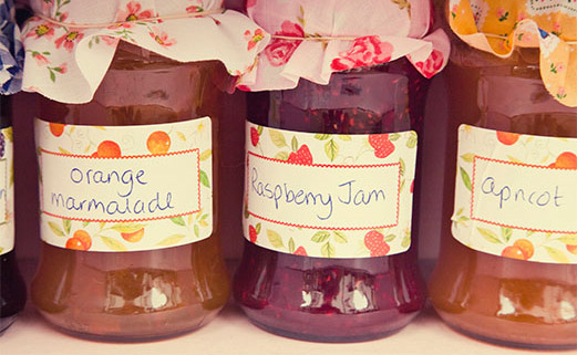 Orange, raspberry and apricot labelled jam jars