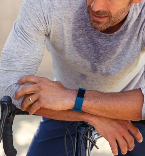 Man resting arms whilst on bike wearing a fitbit.